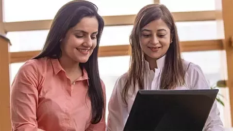 two persons looking at monitor